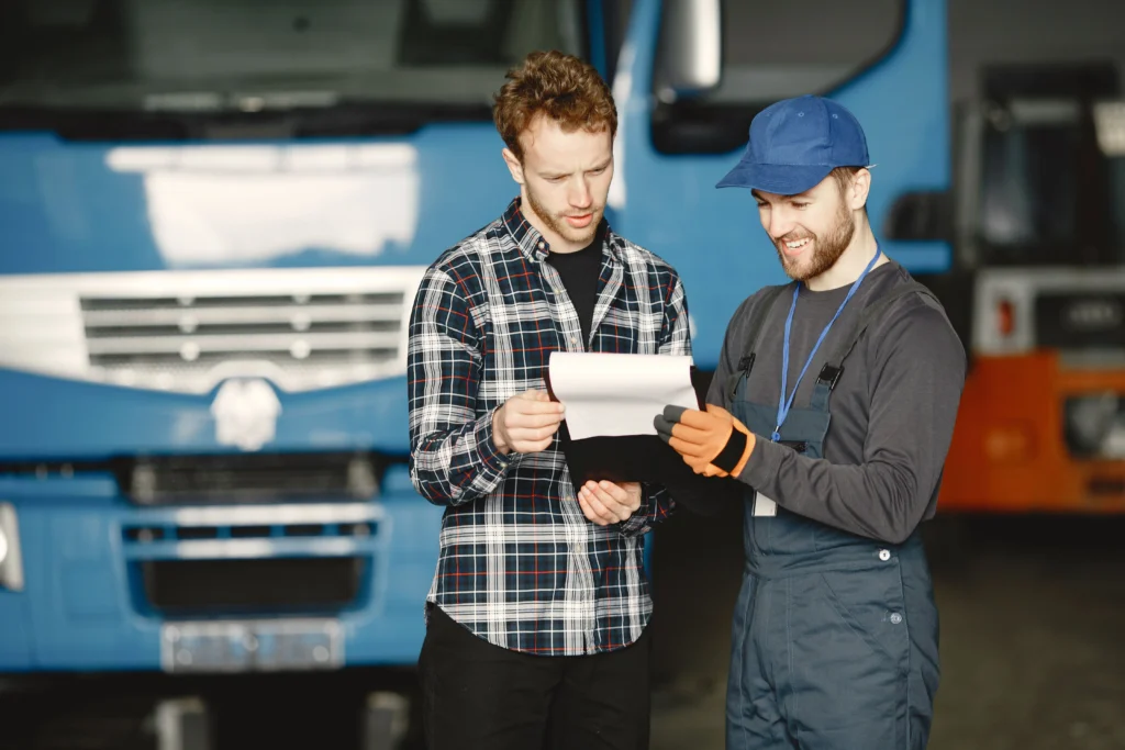 seguro de carga en honduras foto de dos personas revisando una lista de carga frente a un camion