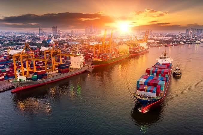 Puerto marítimo con buques y contenedores durante una operación de importación con la prealerta
